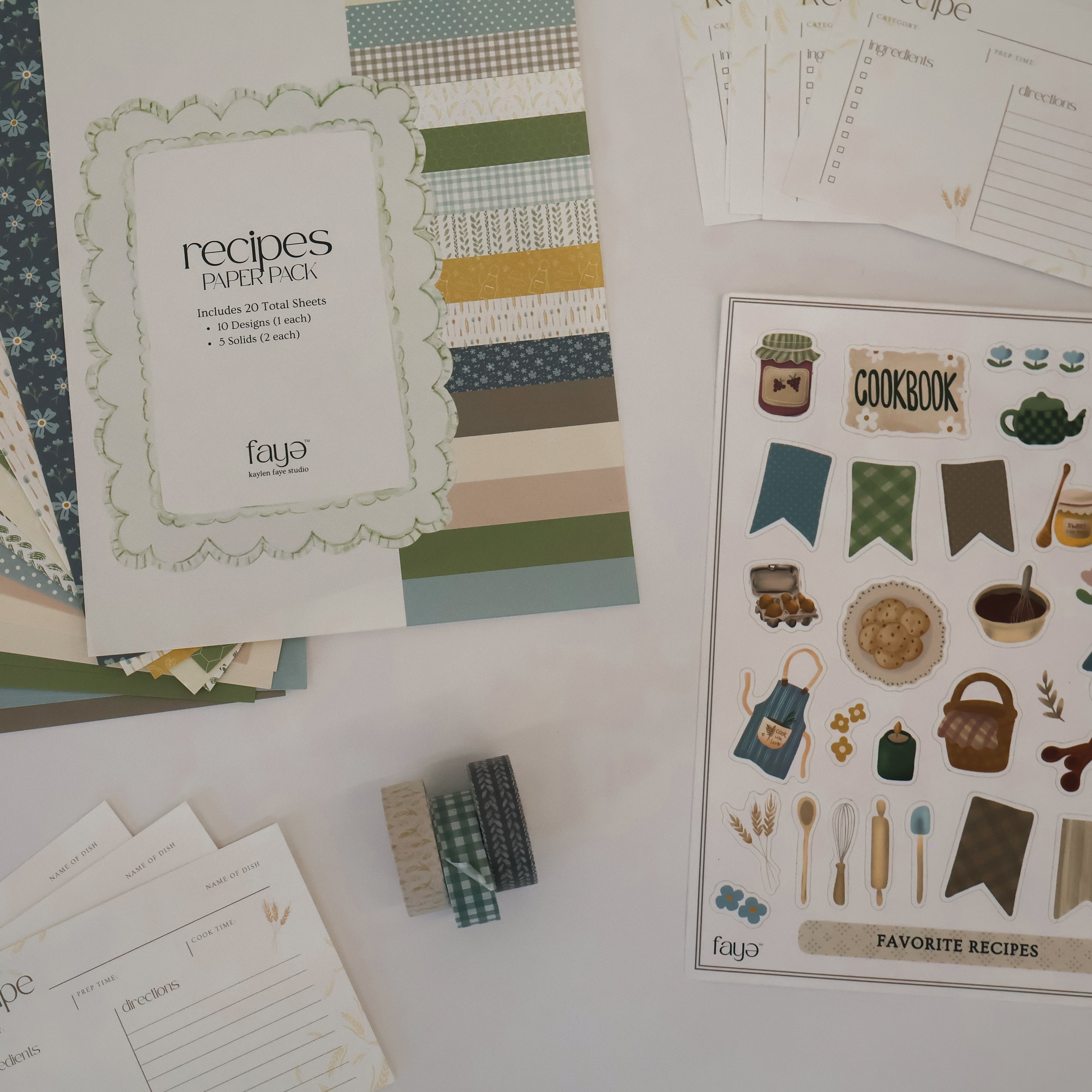 Collection of stationery items including paper, stickers, and recipe cards on a white surface.