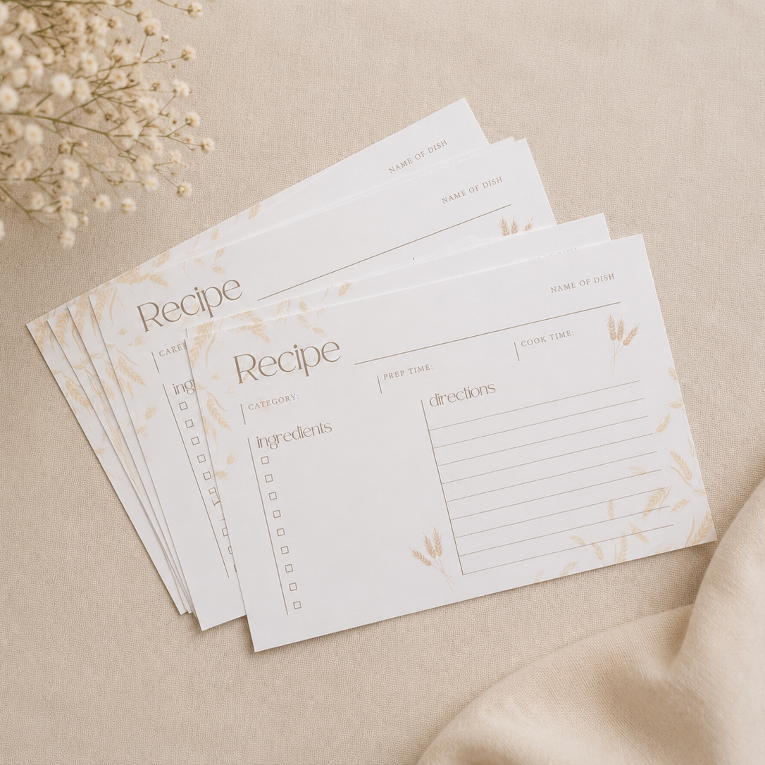 Stack of recipe cards on a beige surface with dried flowers. 