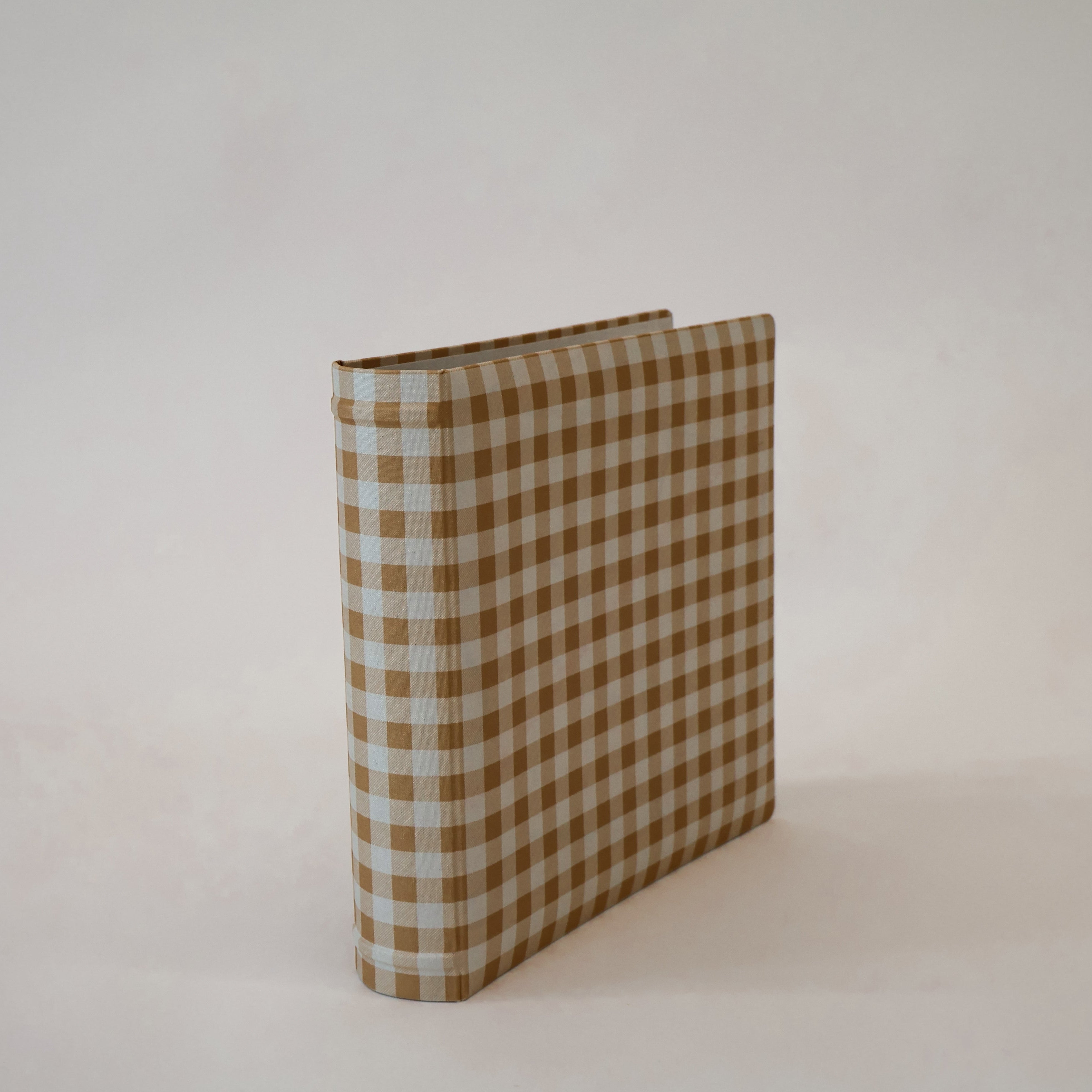 Tan checkered scrapbook albums on a white background