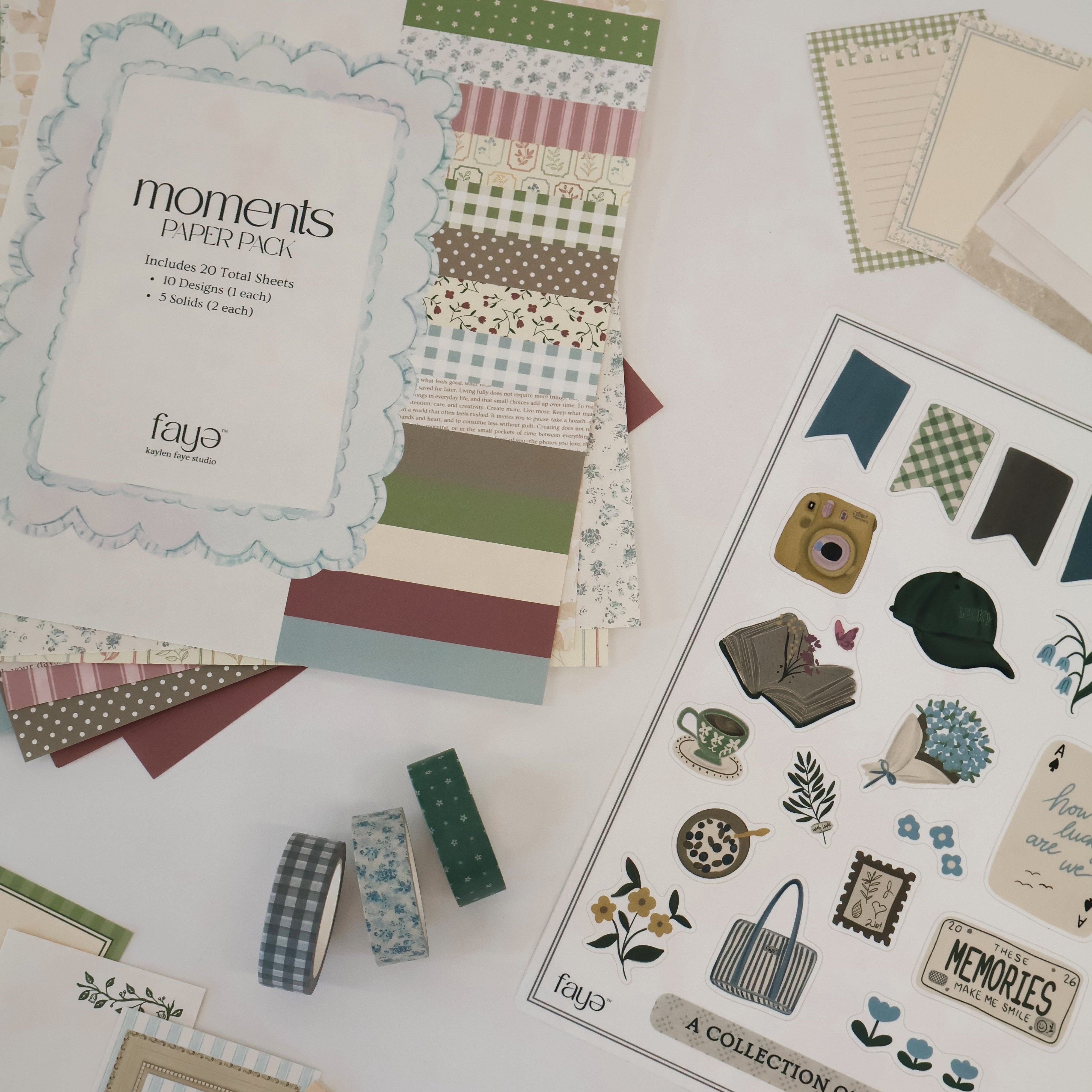 Collection of scrapbooking supplies including paper pads and stickers on a white surface.